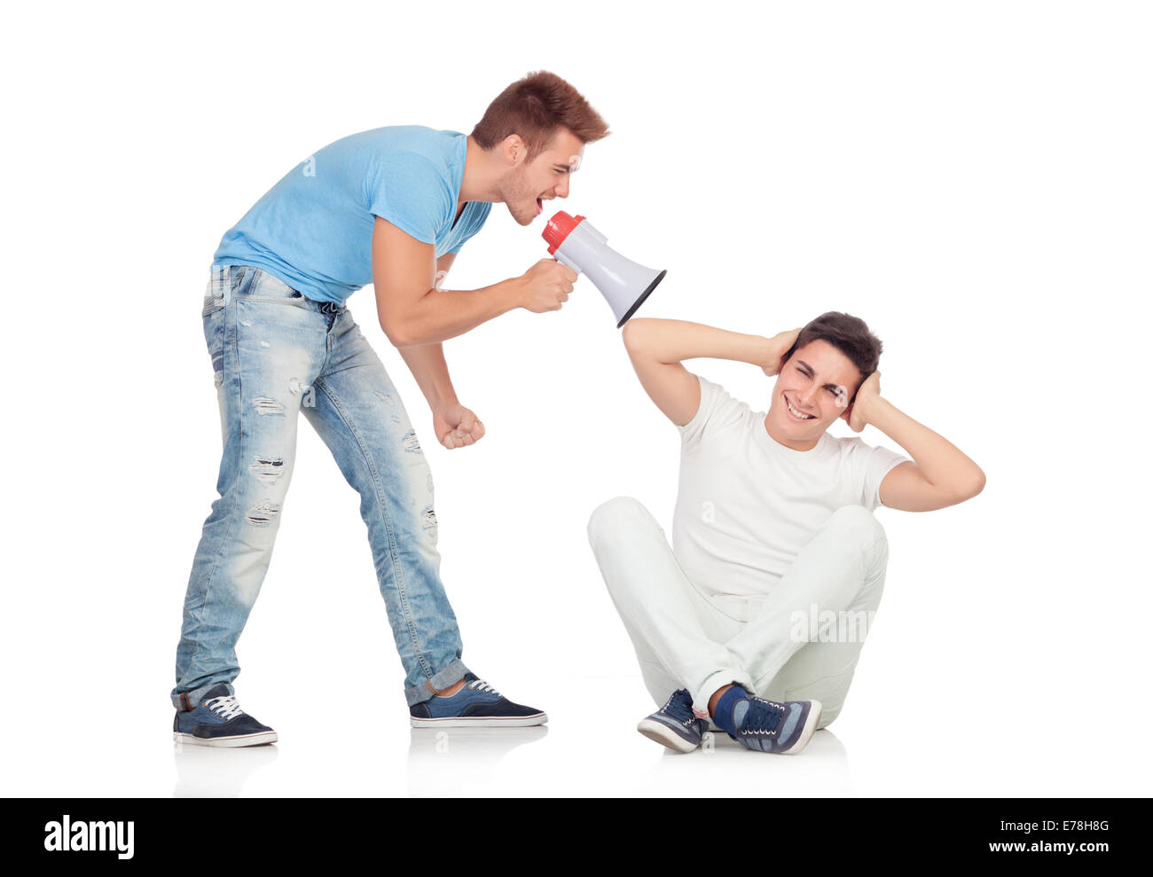 Young men screams to his friend through a megaphone isolated on a white background Stock Photo