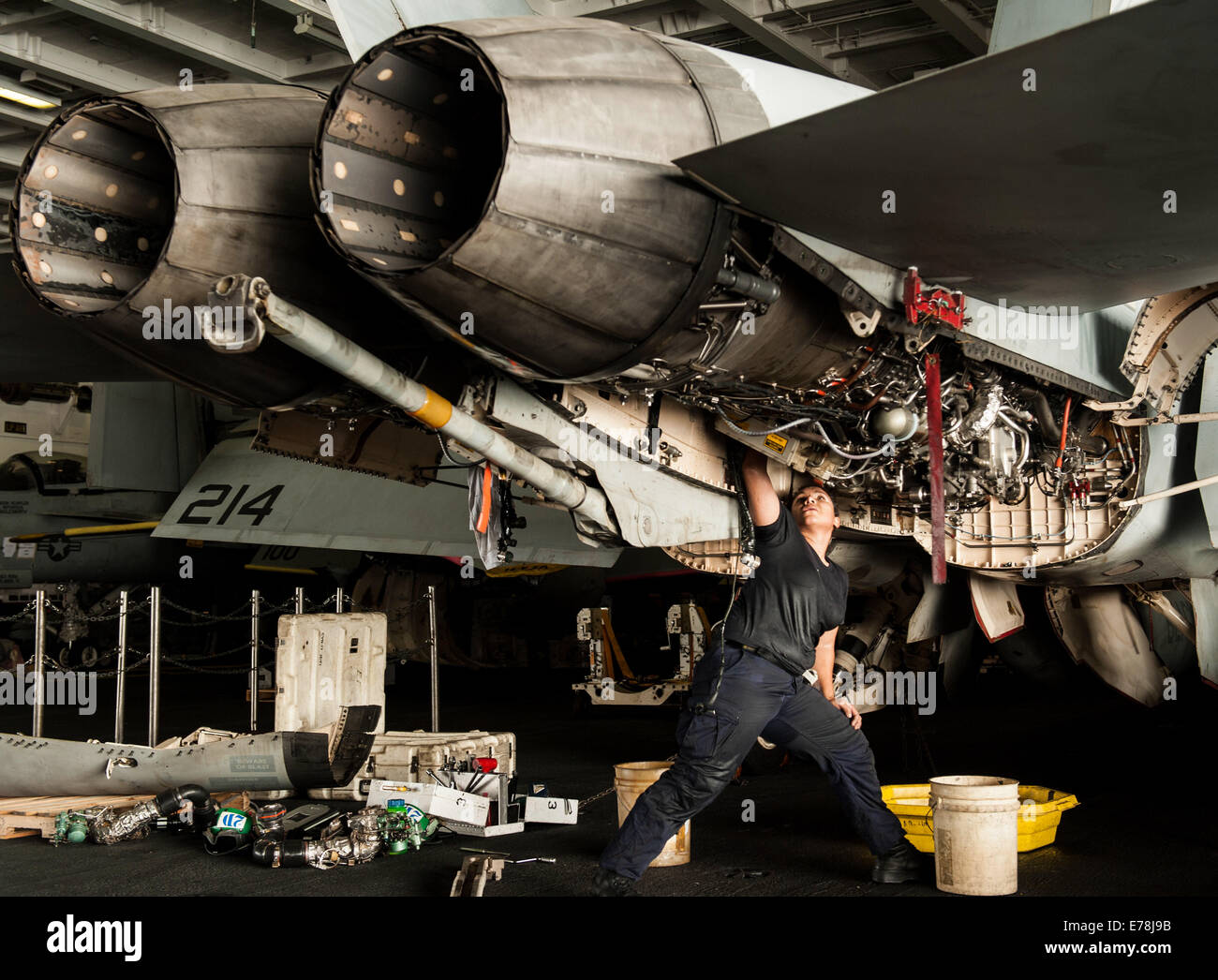 U.S. Navy Aviation Machinist's Mate 2nd Class Alexandra Mimbela performs maintenance on an F/A-18F Super Hornet aircraft assigned to Strike Fighter Squadron (VFA) 213 aboard the aircraft carrier USS George H.W. Bush (CVN 77) Aug. 21, 2014, in the Persian Stock Photo