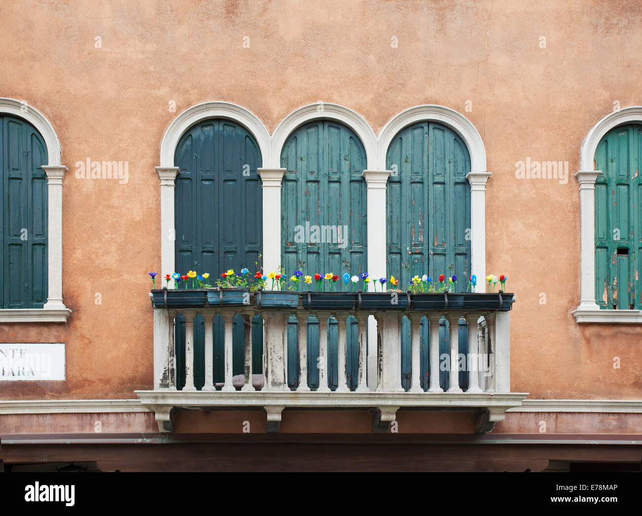 Blossoming flowers decorate the railing of a balcony; Venice, Italy ...