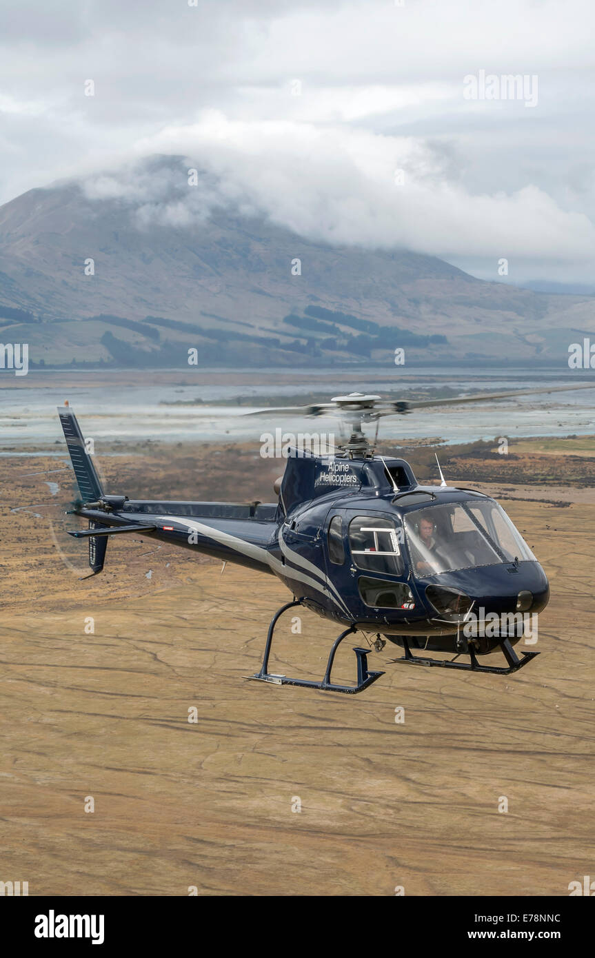 Eurocopter (Aerospatiale) AS350BA Methven over the Rakaia River, South Island, New Zealand Stock Photo