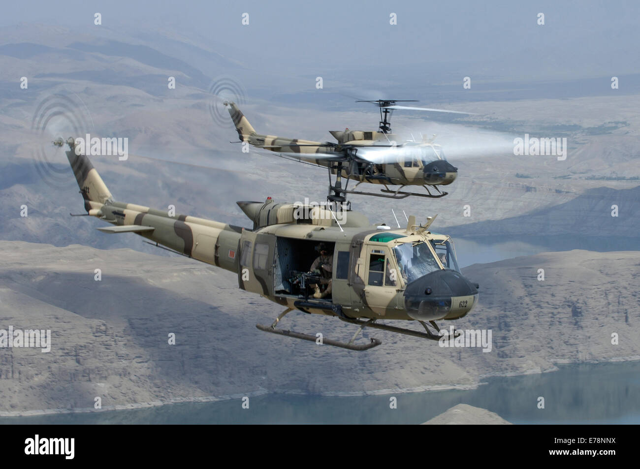 Bell Huey IIs in flight over Naghlu dam, Afghanistan. Stock Photo