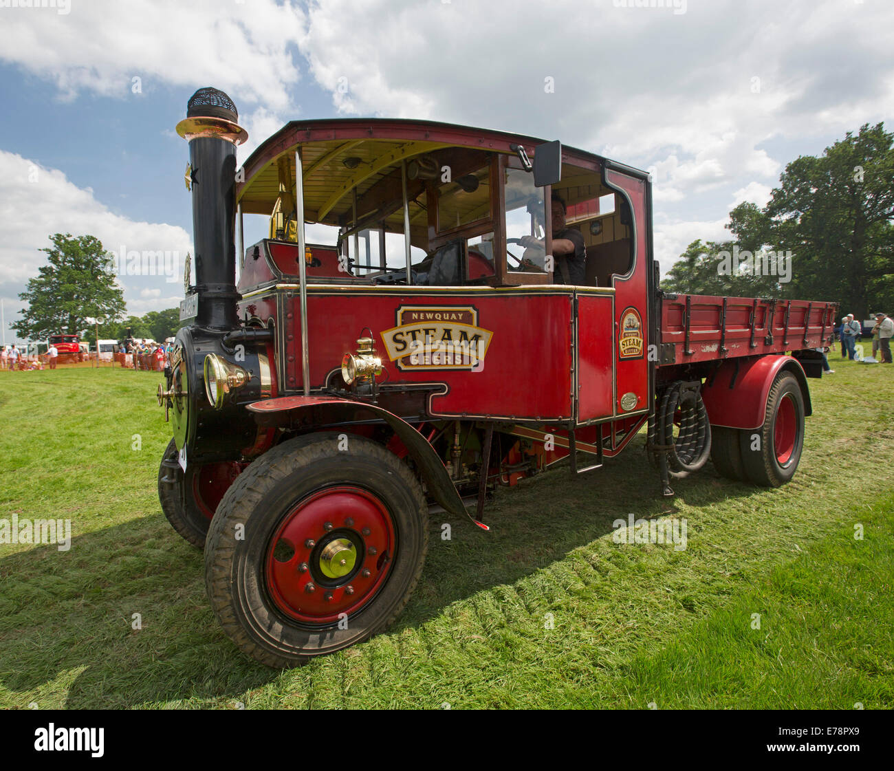Immaculately restored operational steam lorry with bright red paintwork on display at English country fair Stock Photo