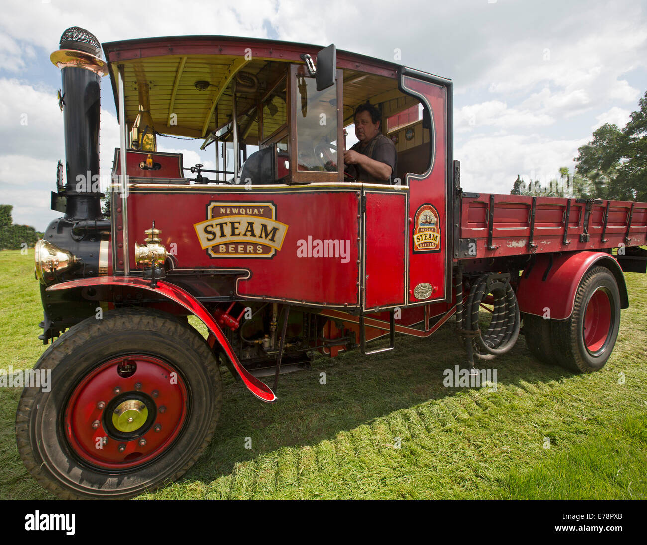 Immaculately restored operational steam lorry with bright red paintwork on display at English country fair Stock Photo