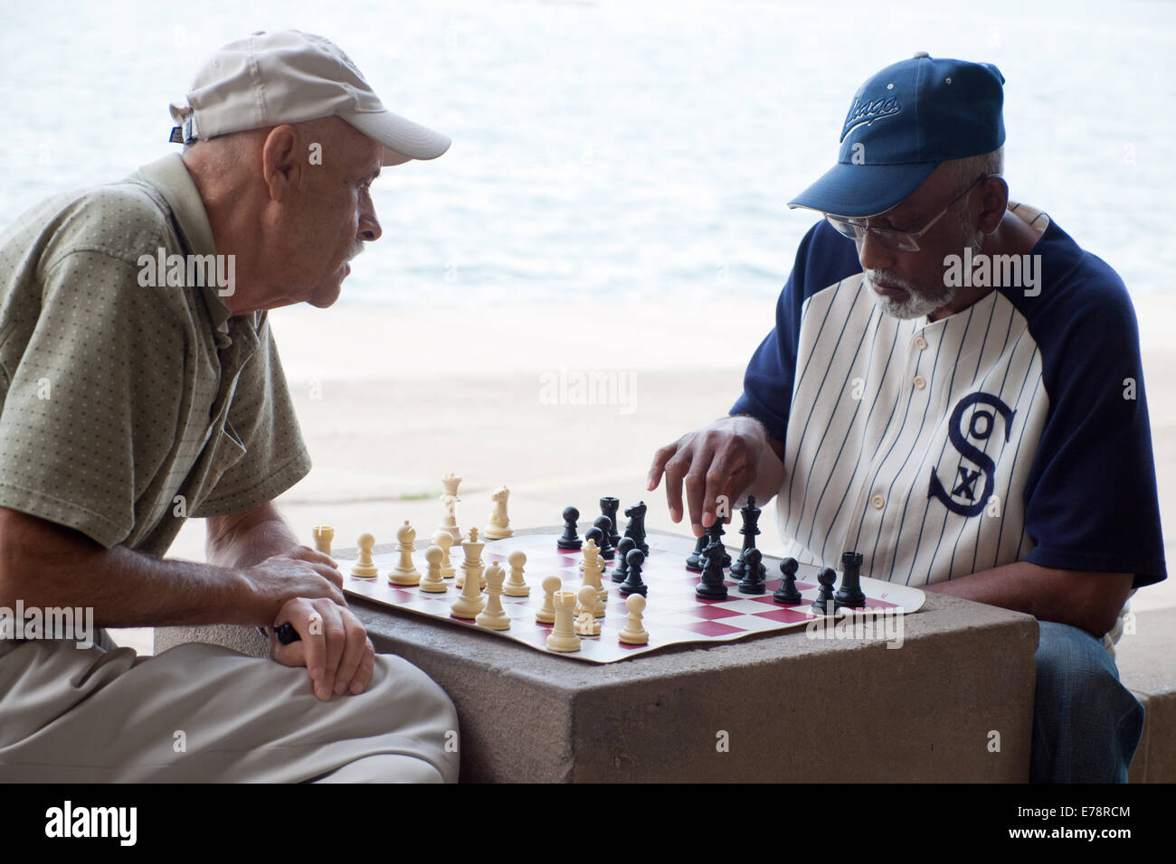 Two retired gentlemen enjoy a game of chess at the North Avenue Beach Chess Pavilion in Chicago, Illinois. Stock Photo