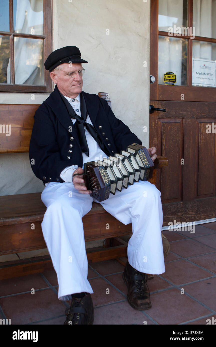 A street performer dressed as an old sailor plays sea chanteys at the ...
