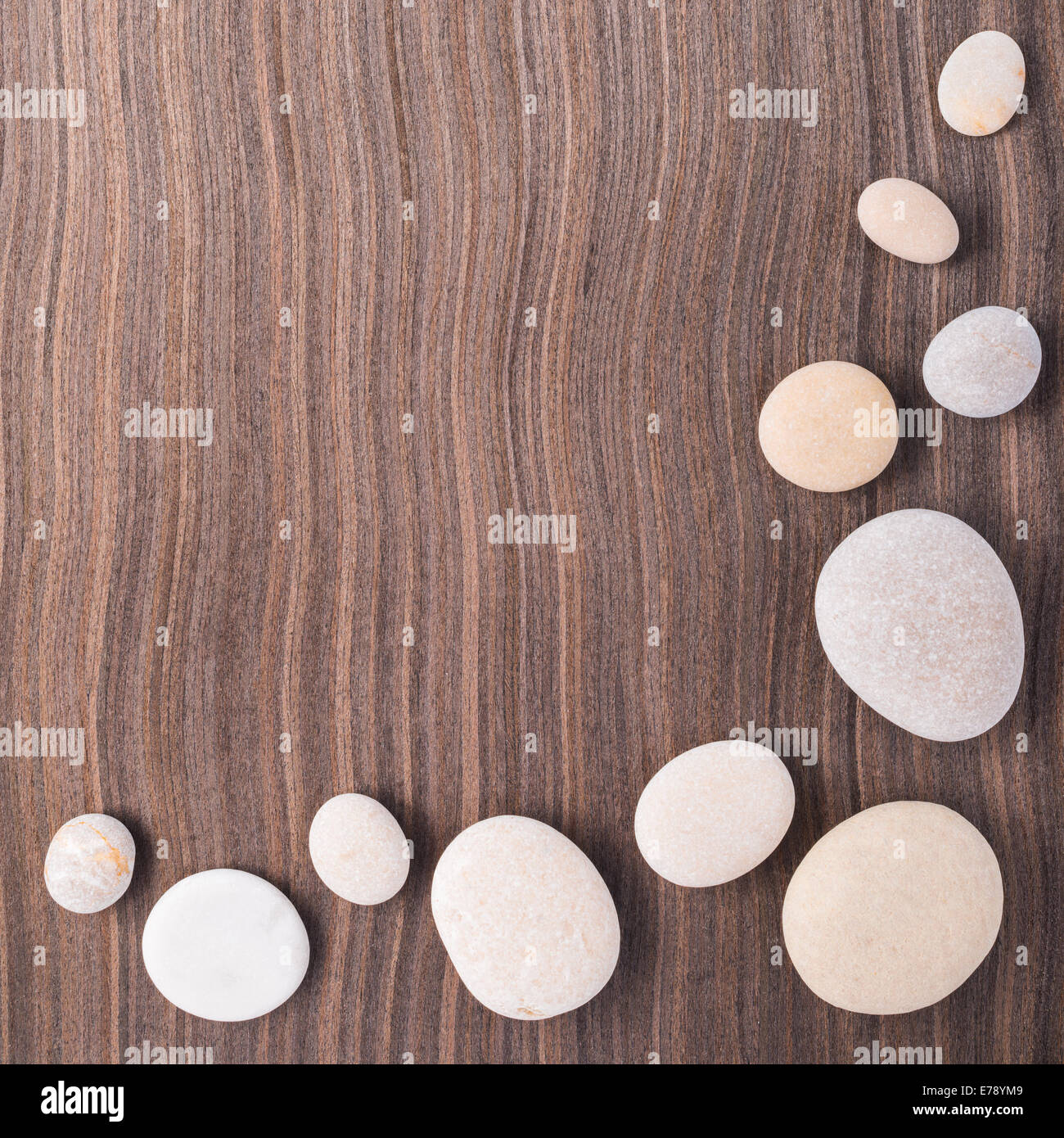 light pebbles on wooden ebony tree background Stock Photo