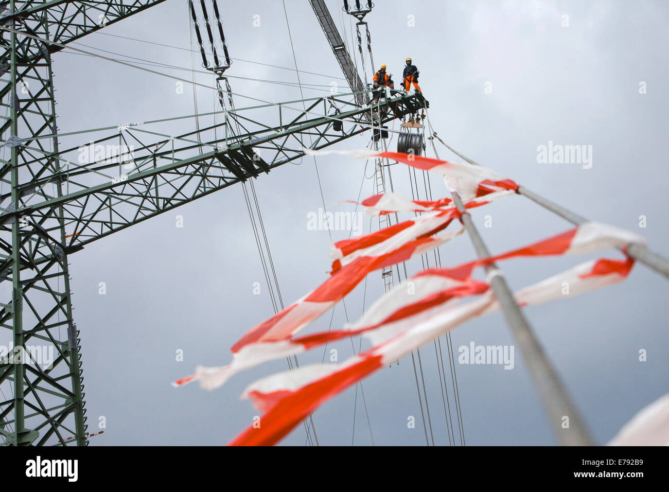 Overhead transmission cable installers installing insulated cable on