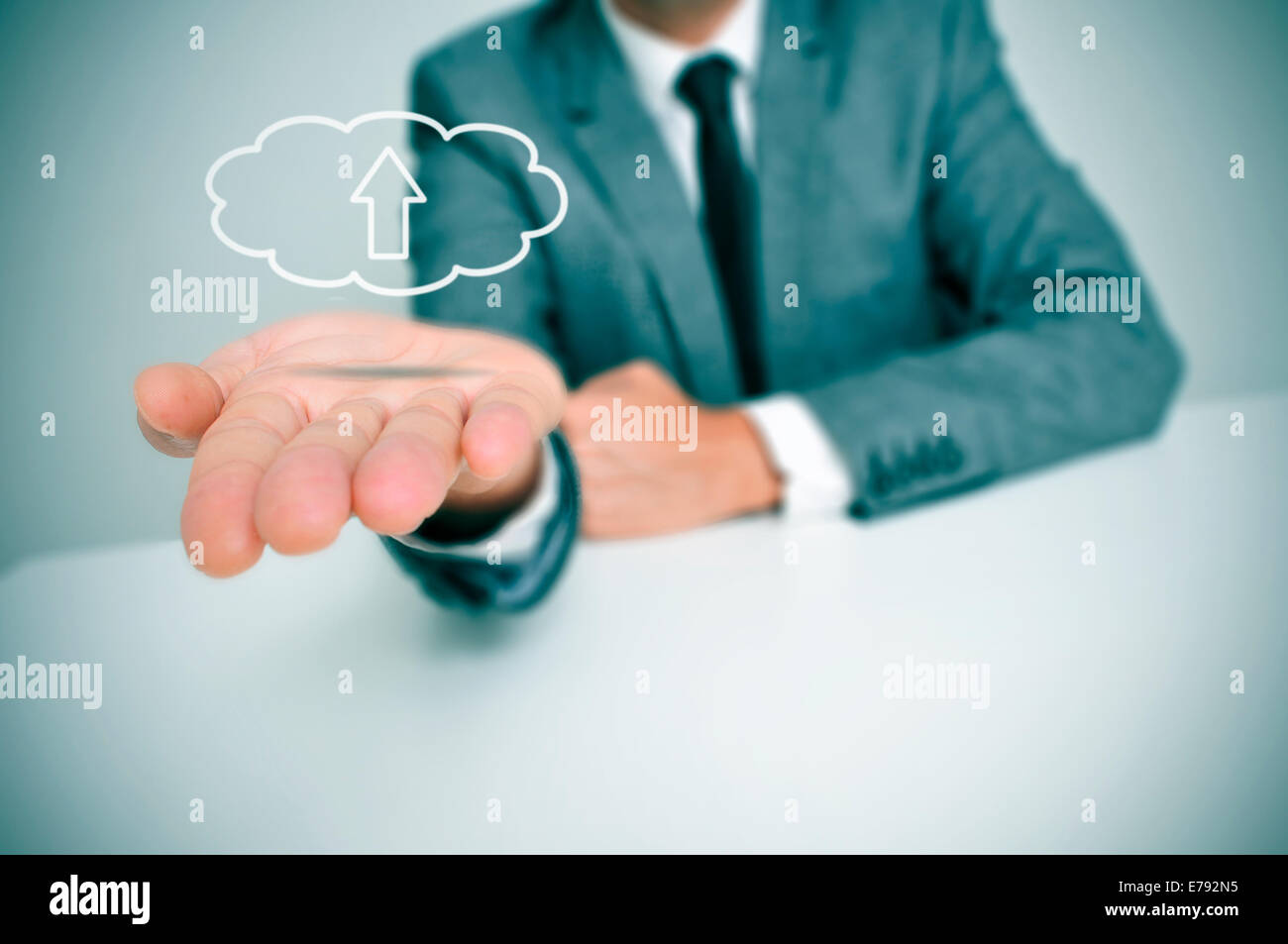 a man with a drawing of a cloud with an arrow inside, depicting the concept of upload to the cloud storage Stock Photo