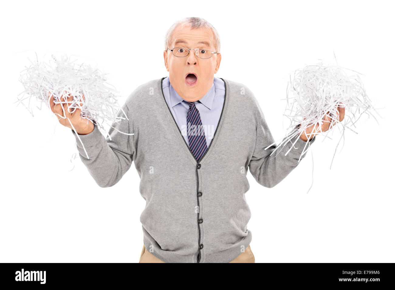 Worried senior holding a pile of shredded paper isolated on white background Stock Photo