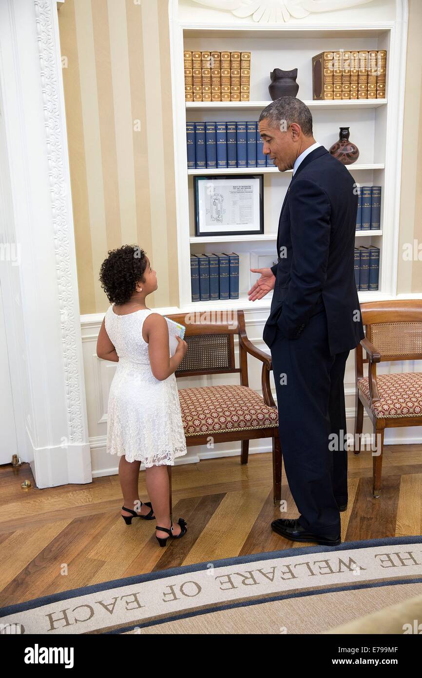 US President Barack Obama visits with Ella Wade, a 7-year-old Make-A-Wish recipient, in the Oval Office of the White House June 11, 2014 in Washington, DC. Stock Photo