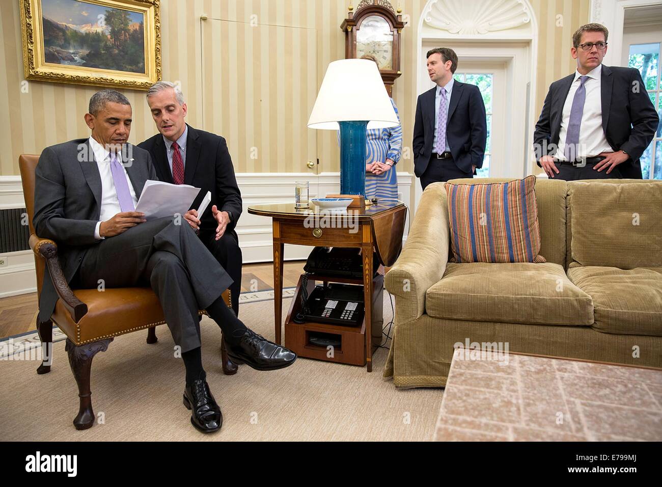 US President Barack Obama confers with Chief of Staff Denis McDonough before delivering statements to the press with Prime Minister Tony Abbott of Australia in the Oval Office of the White House June 12, 2014 in Washington, DC. Standing at right are: Jennifer Palmieri, Director of Communications; Principal Deputy Press Secretary Josh Earnest; and Press Secretary Jay Carney. Stock Photo