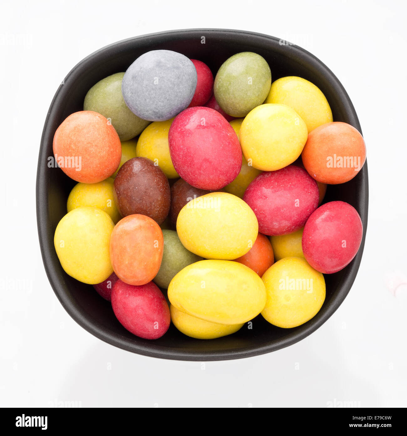 Bright sugar coated sweets in bowl, isolated. Stock Photo