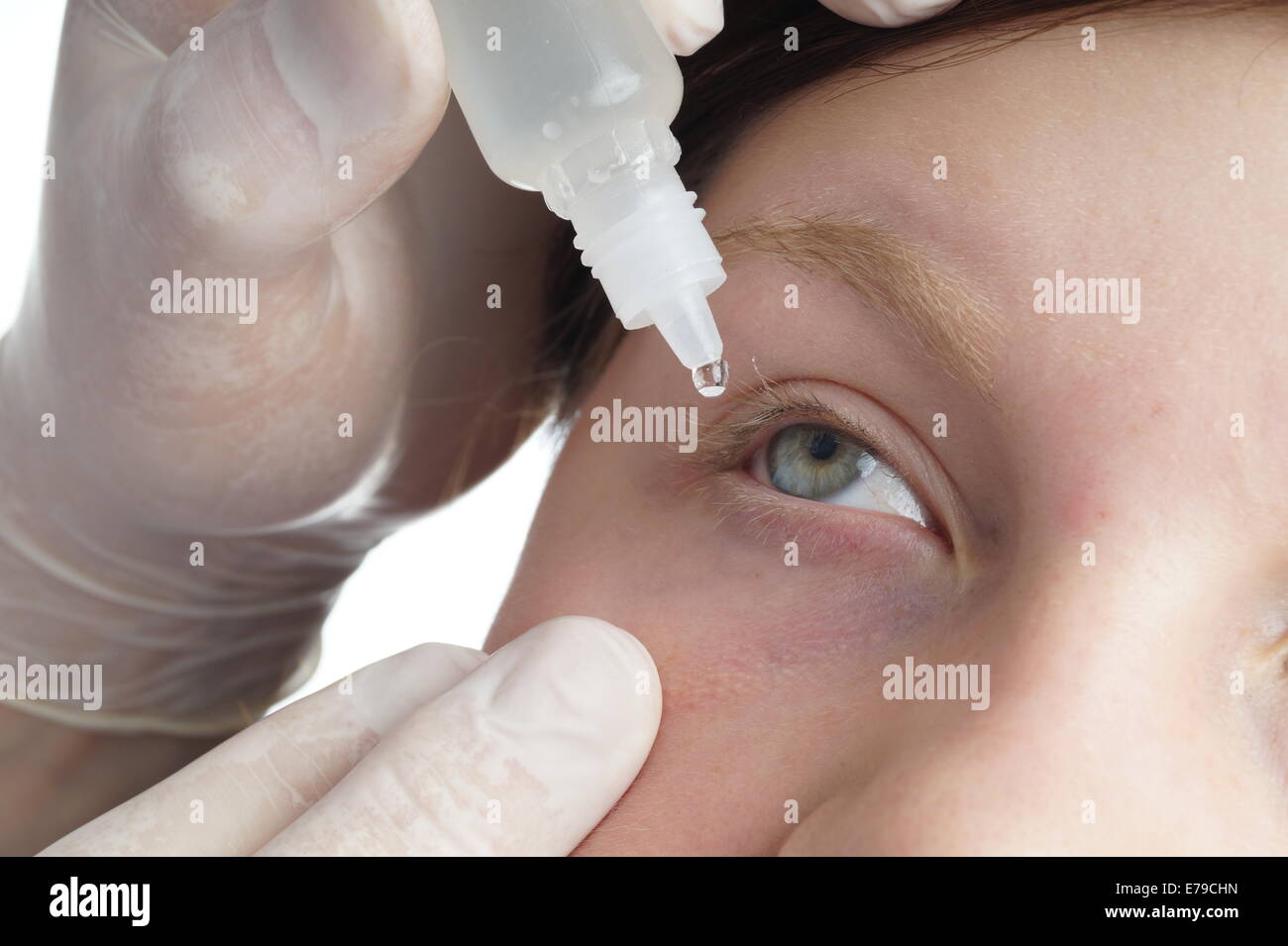 Nurse giving a child eye drops. Medical procedure Stock Photo