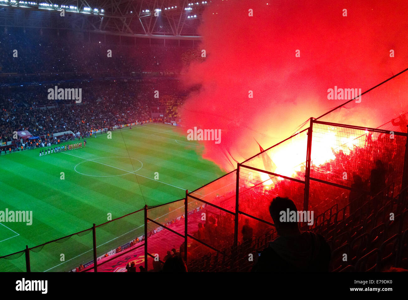 Galatasaray fans light flares and sing at the start of a Champions League match. Stock Photo