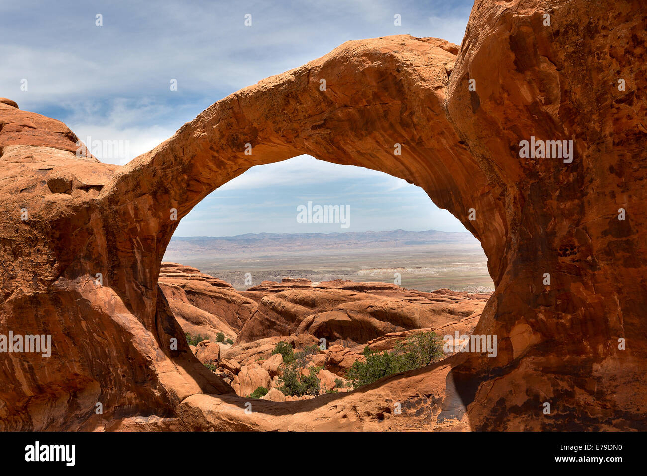 landscape seen through upper Double O Arch in Arches NAtional Park Utah USA Stock Photo