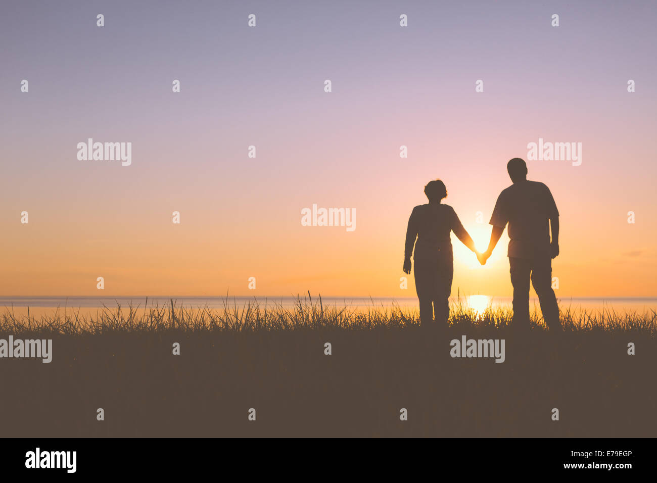 Senior couple holding hands silhouettes Stock Photo