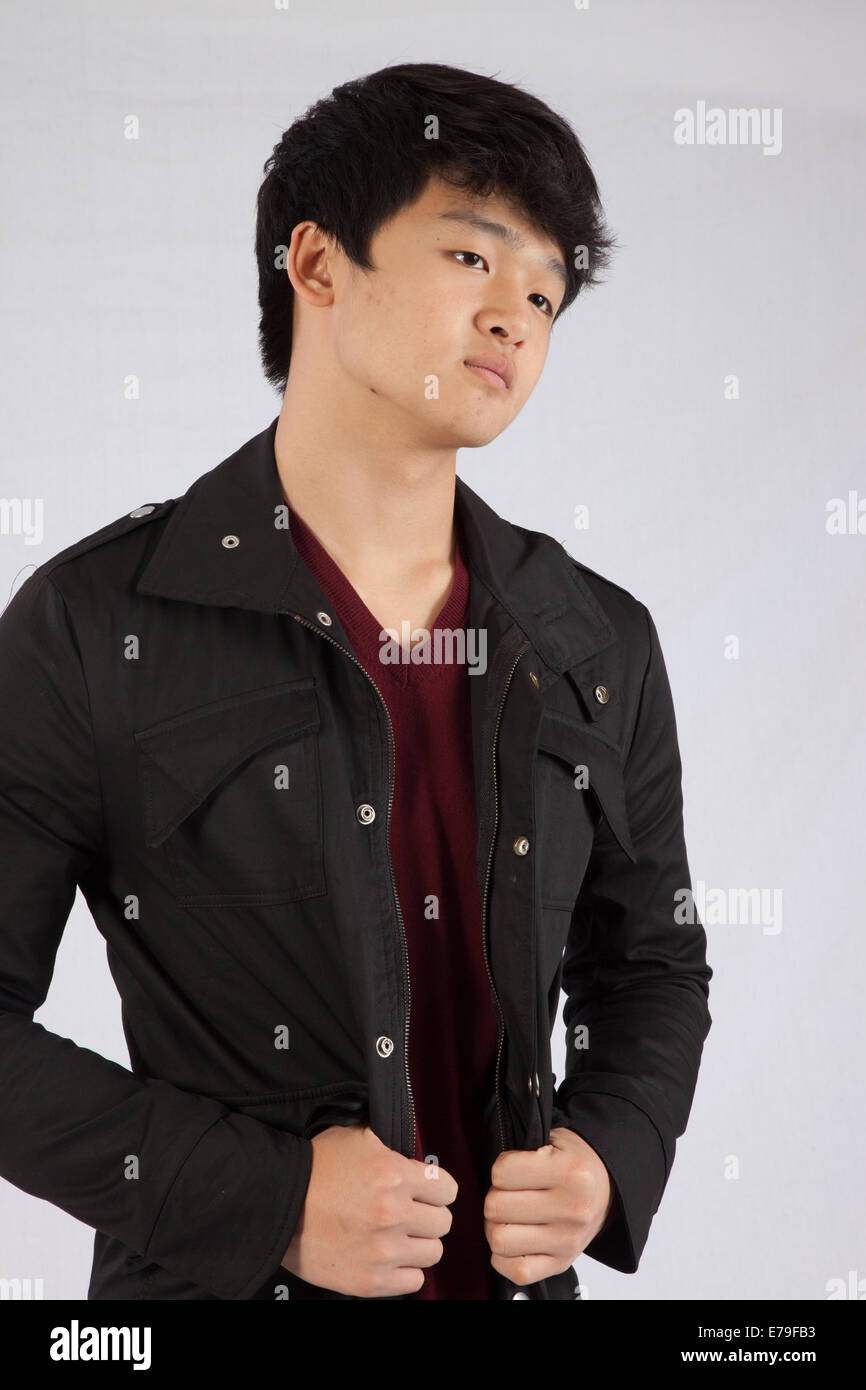 Handsome East Asian man wearing a jacket and with a thoughtful expression Stock Photo