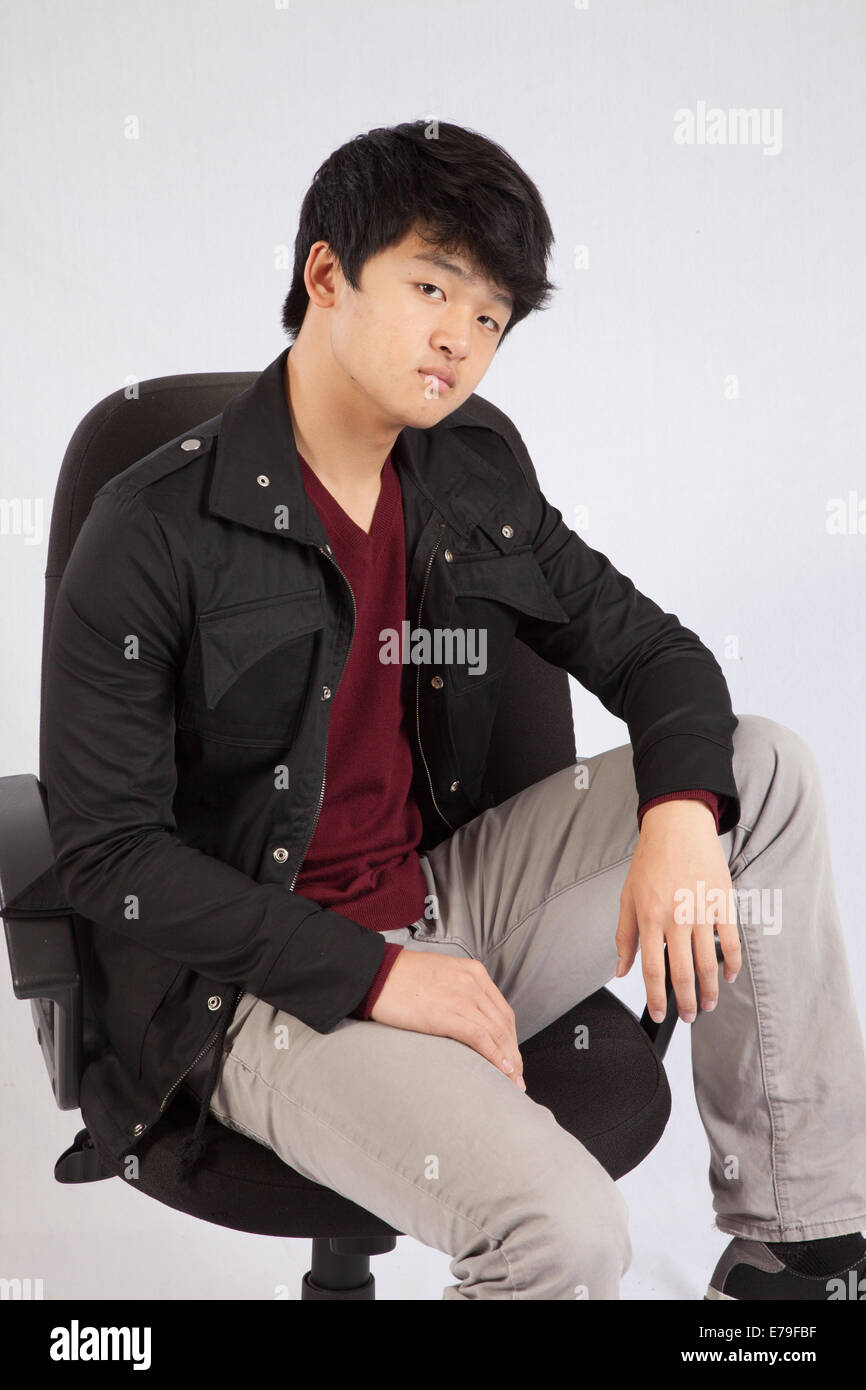 Asian man in a jacket looking thoughtfully at the camera Stock Photo