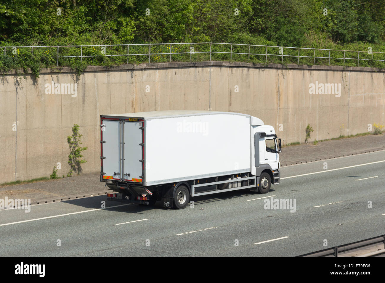 Unliveried  white Mercedes 1824 truck with Bevan streamlined box body lorry, travelling east on the four lane section of the M60 Stock Photo