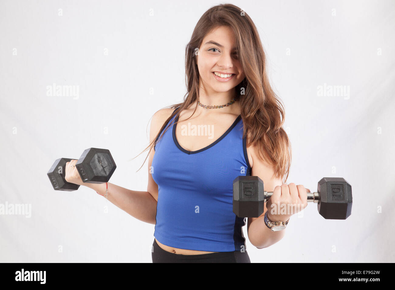 Pretty Caucasian woman holding dumb bells,  smiling at the camera Stock Photo