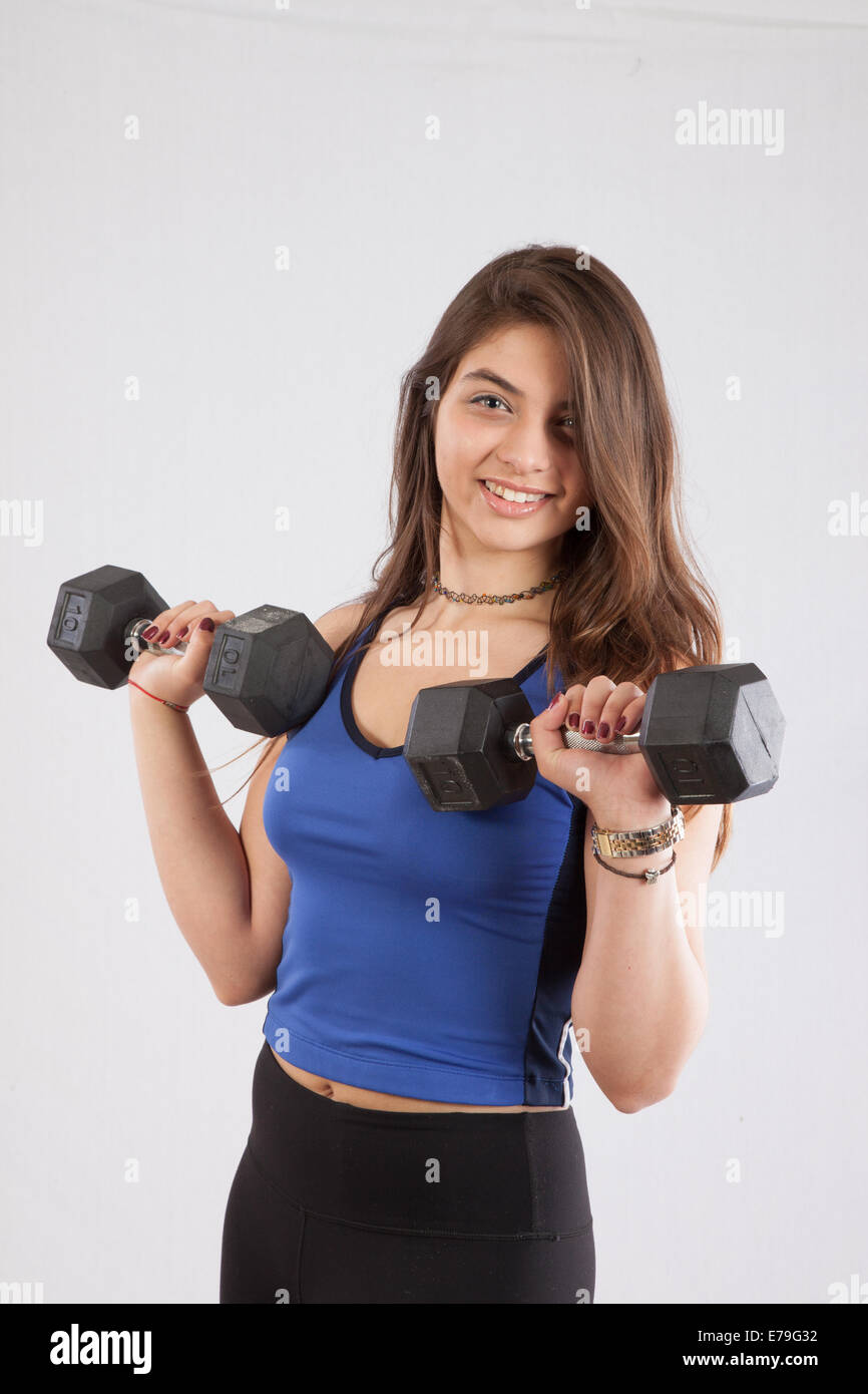 Pretty Caucasian woman holding dumbbells,  smiling at the camera Stock Photo