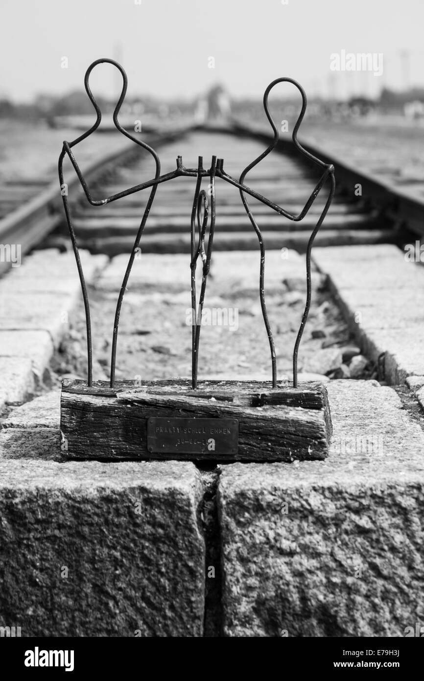 Figures structure and rail tracks leading to entrance gate at the Auschwitz-Birkenau concentration camp, Auschwitz, Poland Stock Photo