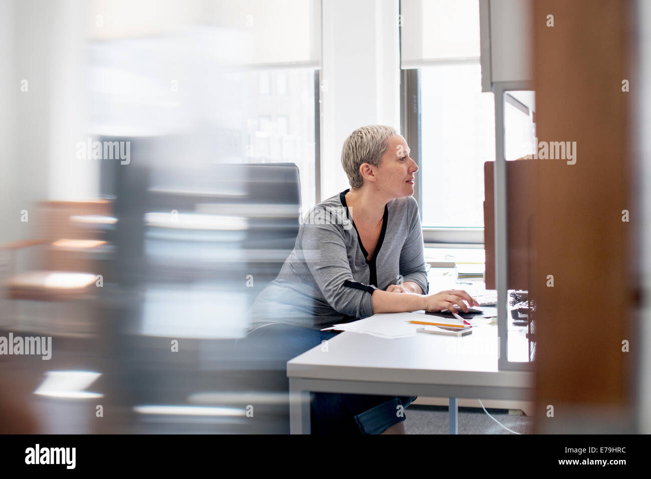 A Woman Working In An Office At Her Desk Using A Computer Mouse