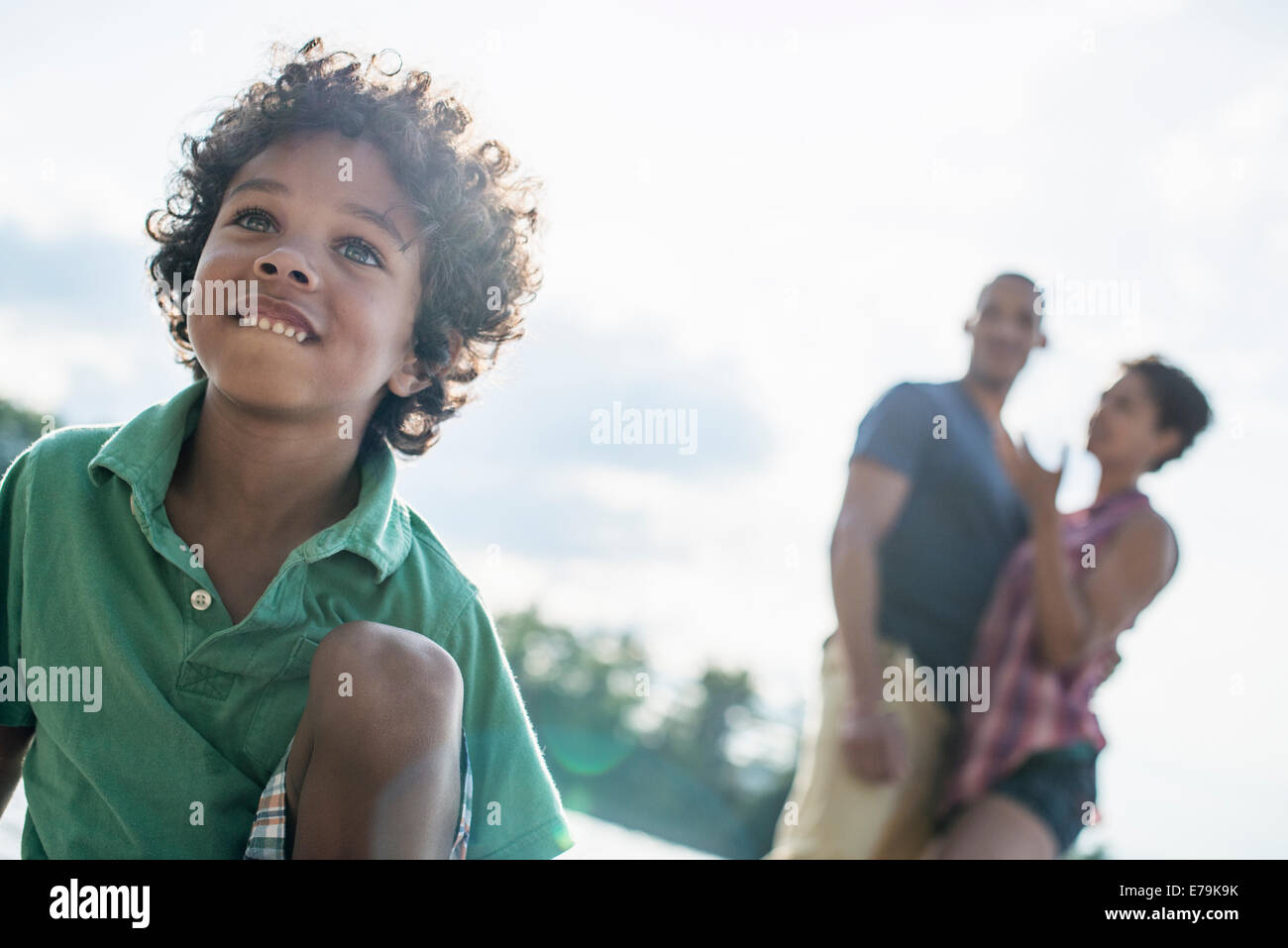 A family, parents and son by a lake in summer. Stock Photo