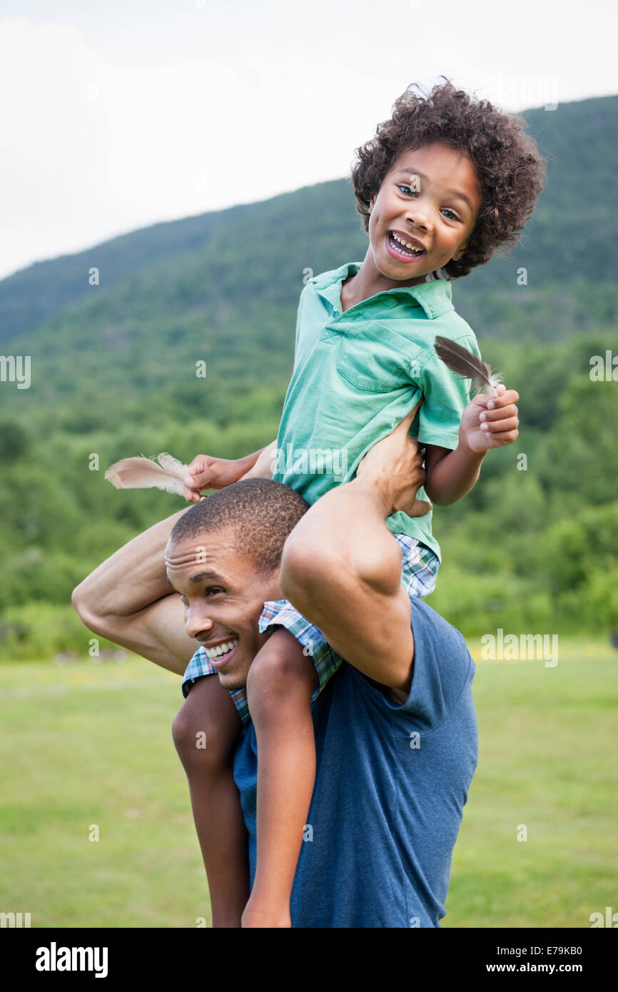 A father lifting his son up onto his shoulders. Stock Photo