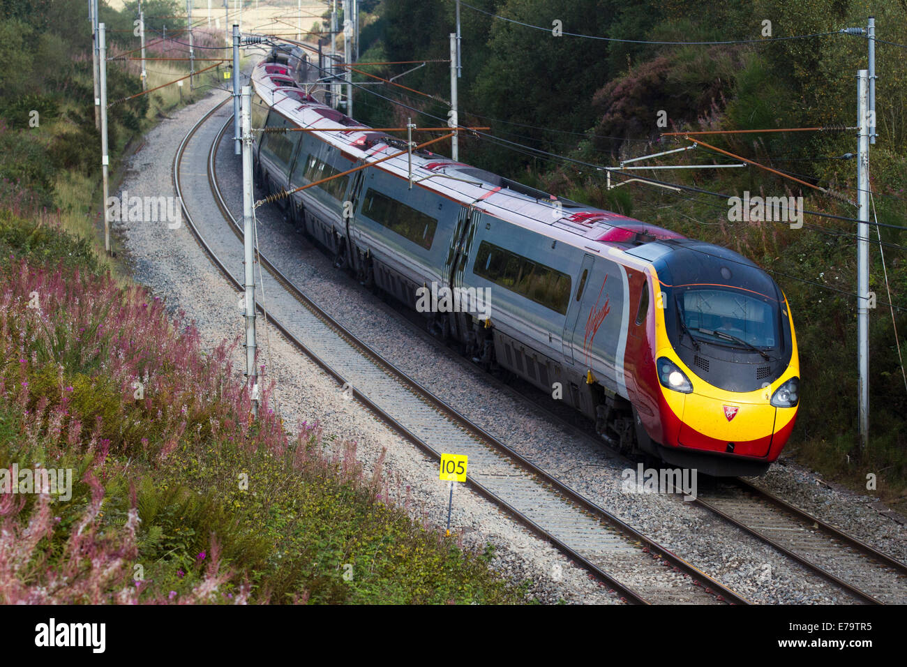 Virgin Voyager Train at Shap, Power lines, and gantries for electric trains. British Railways carriages descending, West Coast Line, Cumbria, UK Stock Photo