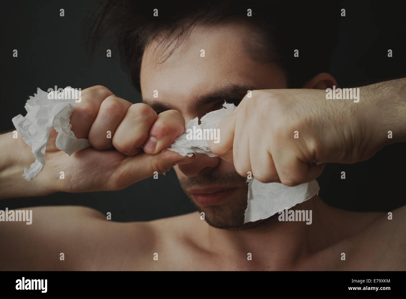 Portrait of a young man tearing paper Stock Photo Alamy