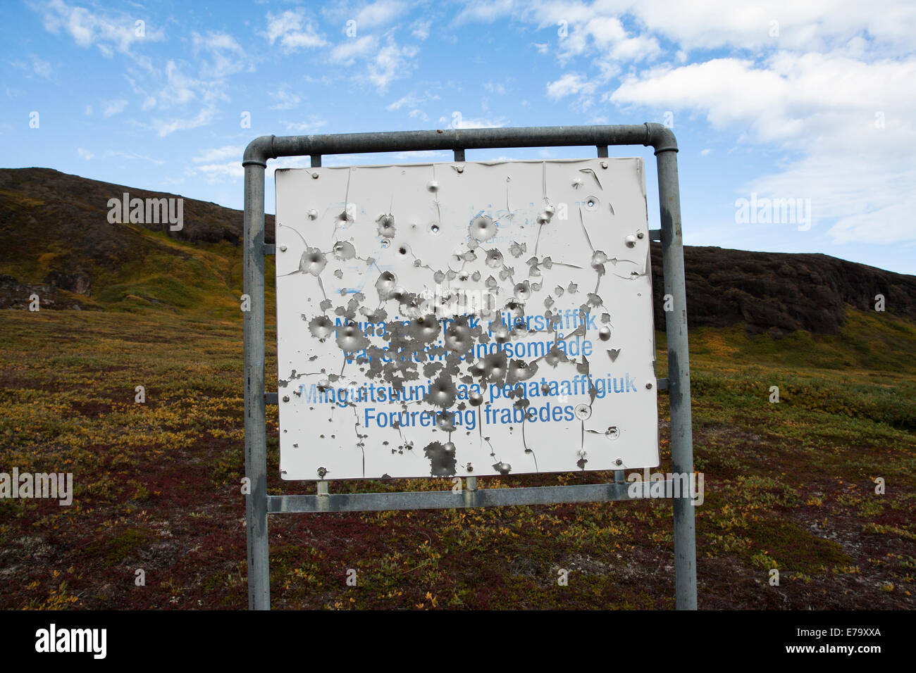 Metal sign in Greenland riddled with bullet holes Stock Photo