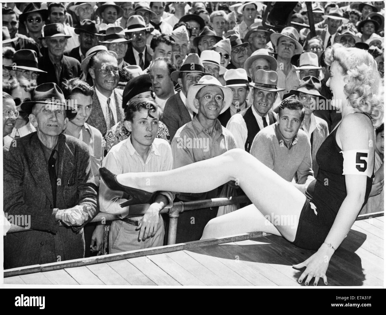 All-Male Crowd Watching Contestant in one-piece Bathing Suit Perform during Beauty Contest, Los Angeles, California, USA, 1943 Stock Photo