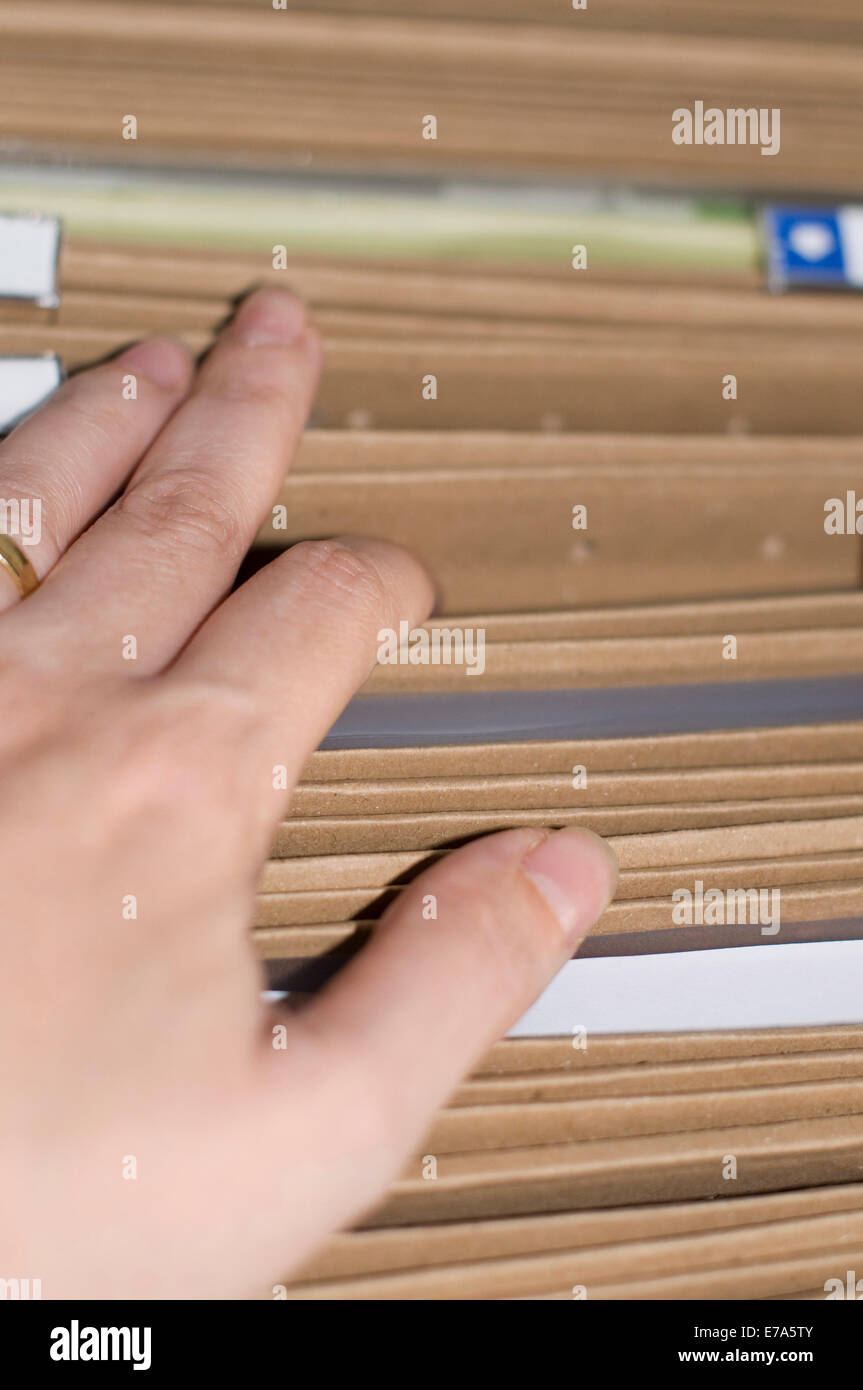 A hand of someone searching a document in a file cabinet Stock Photo