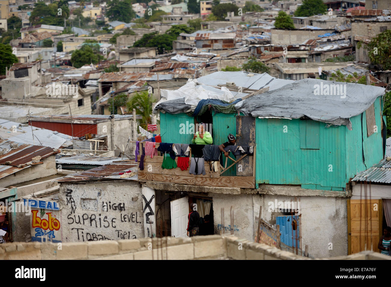 Woman on the balcony of her green-painted shack, Fort National slum, Port-au-Prince, Haiti Stock Photo