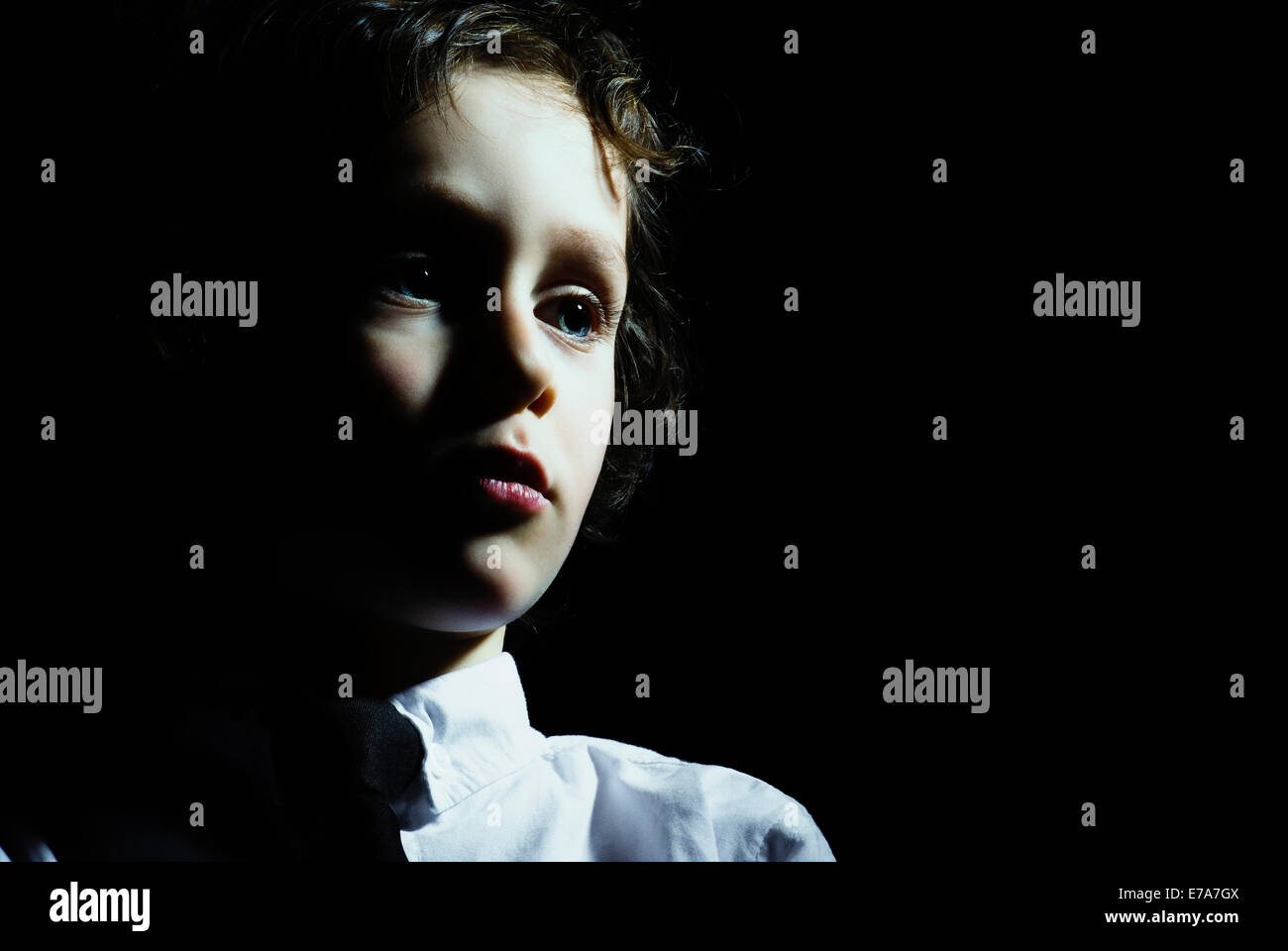 A young boy looking away in contemplation Stock Photo