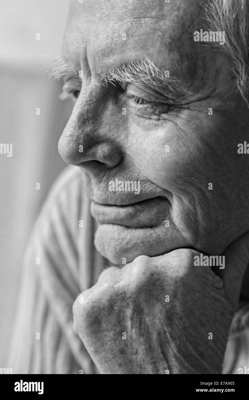 Thoughtful senior man with hand on chin looking away Stock Photo