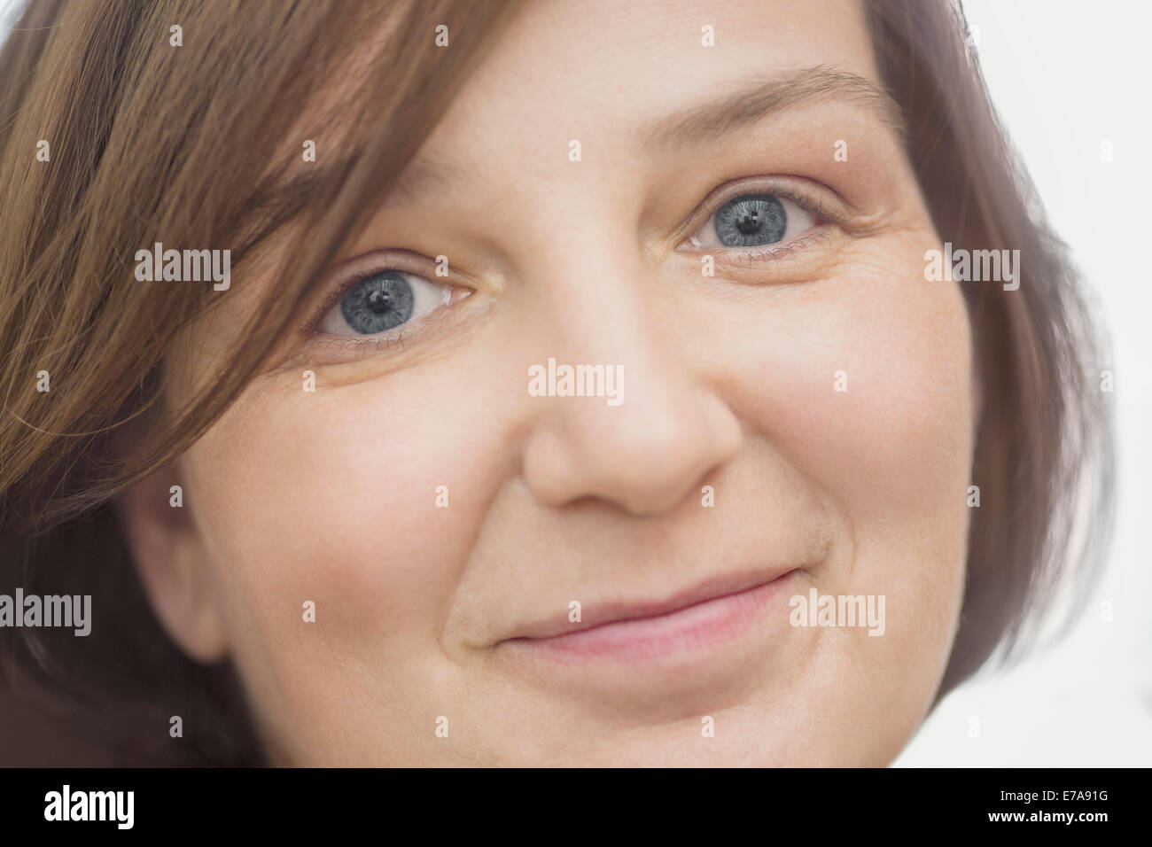 Close-up portrait of happy mature woman over white background Stock Photo
