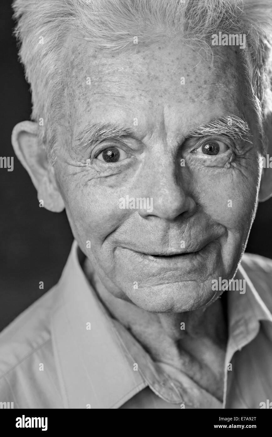 Close-up portrait of smiling senior man over black background Stock Photo