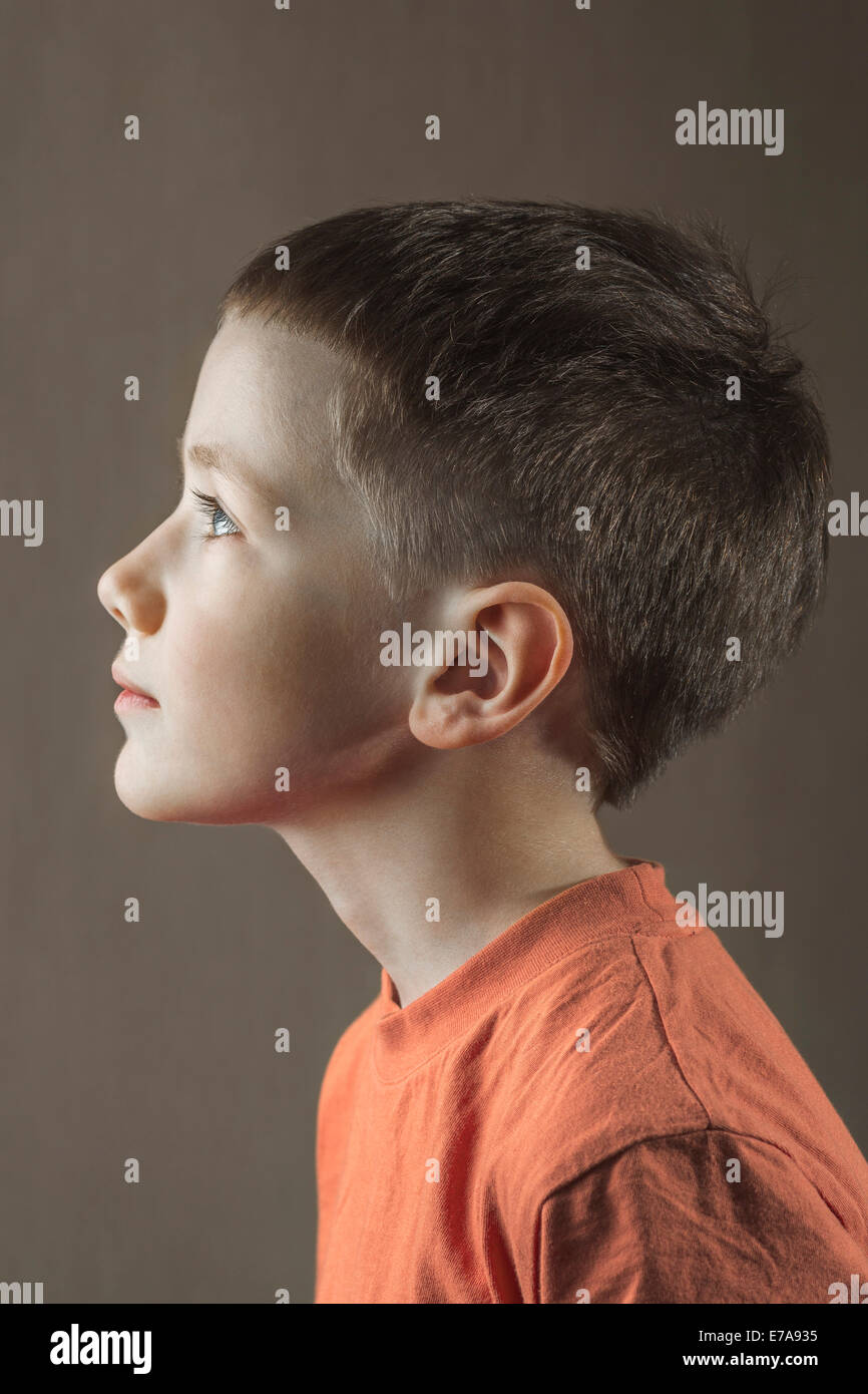Profile shot of boy looking away over colored background Stock Photo
