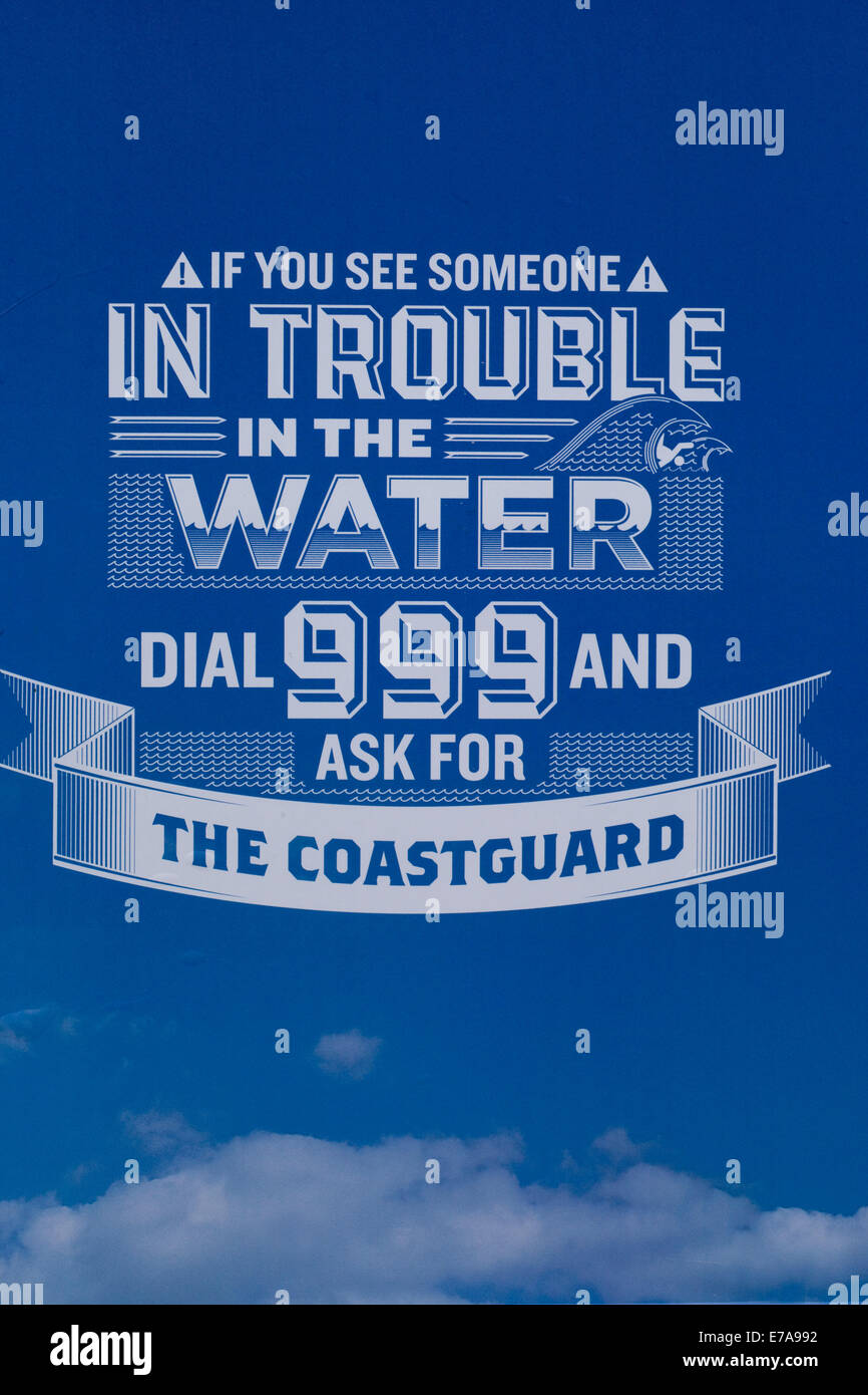 Public warning Sign 'If you see someone in trouble in the water dial 999 and ask for the coastguard' Stock Photo