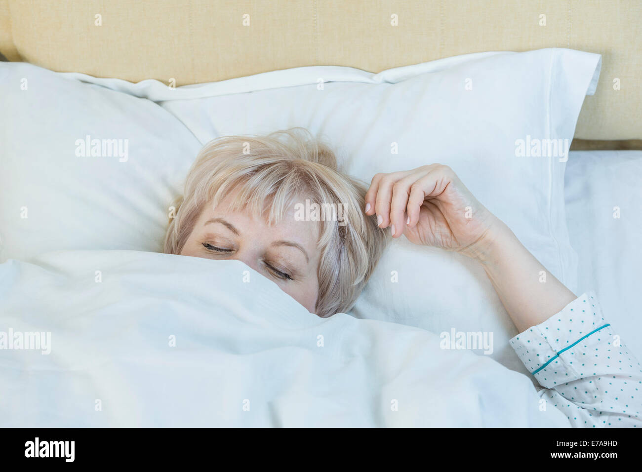 Mature woman sleeping in bed Stock Photo