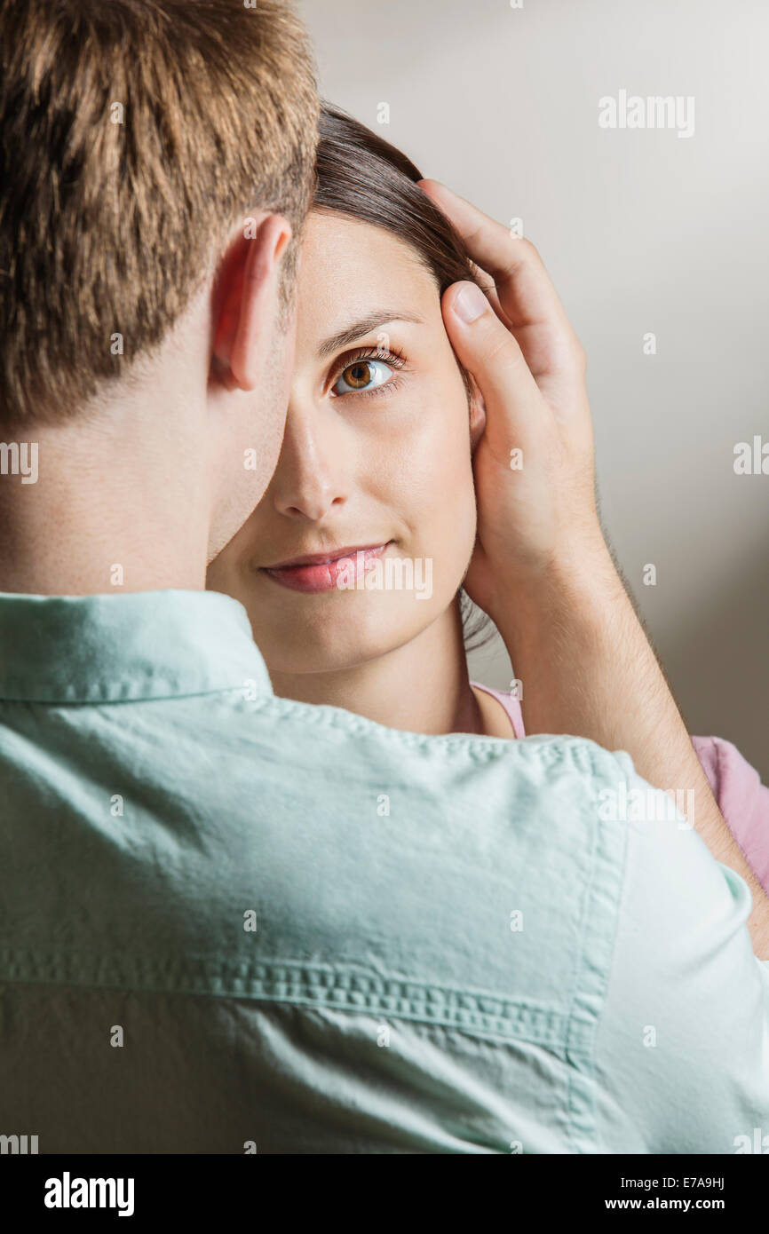 Young woman looking at loving man in house Stock Photo