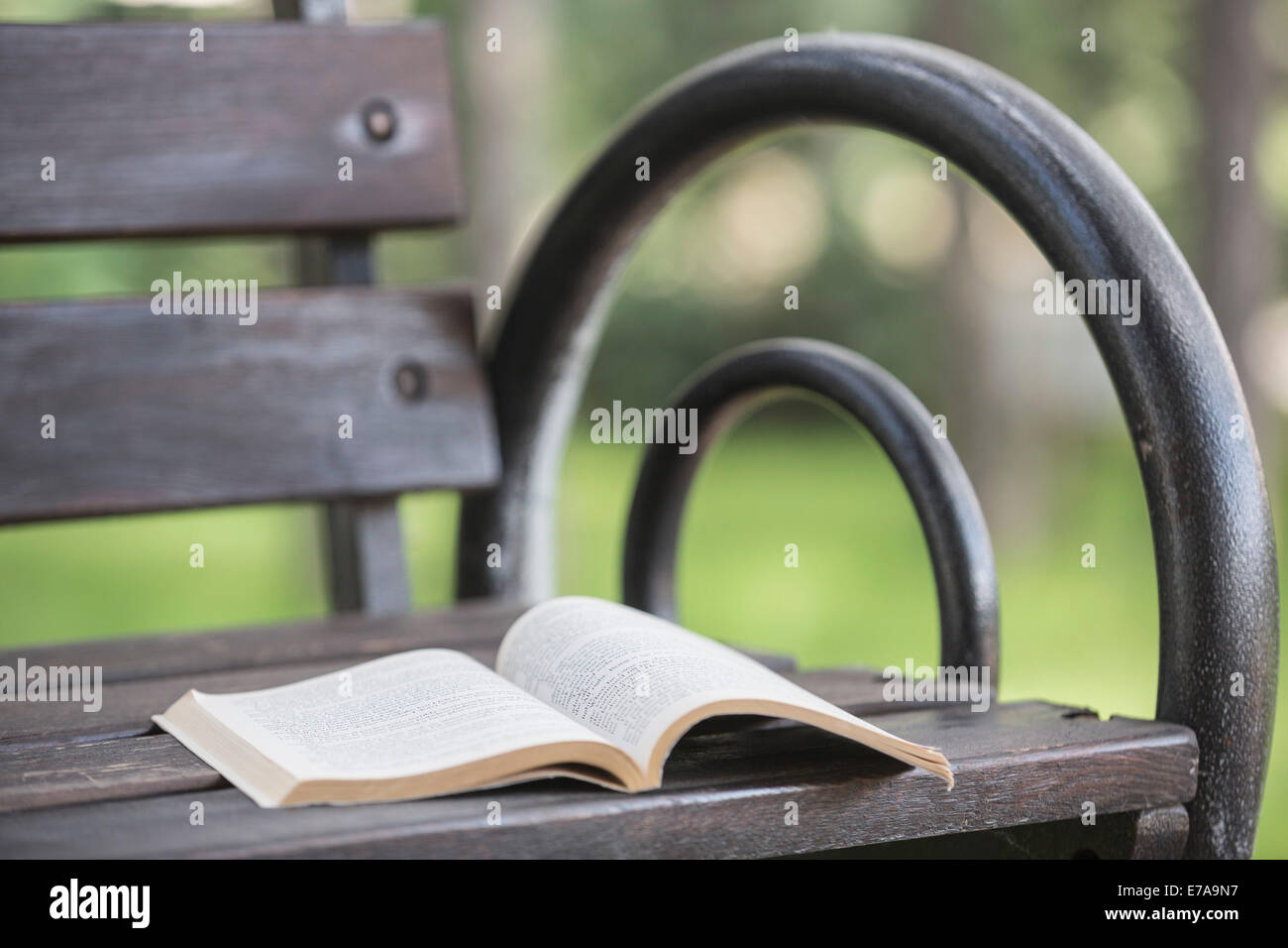 Open book on bench in park Stock Photo
