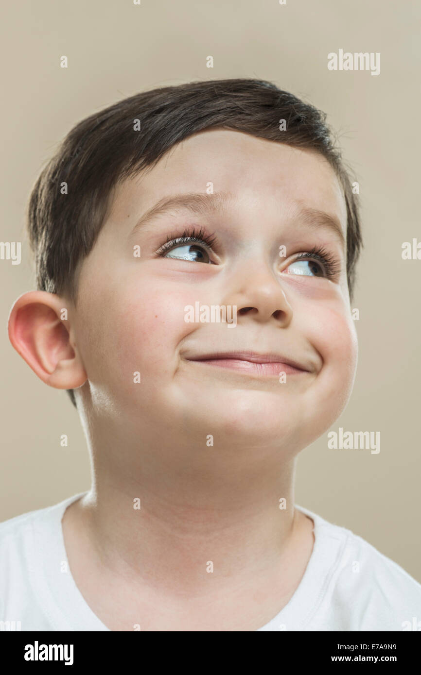 Close-up of cute boy smiling against beige background Stock Photo
