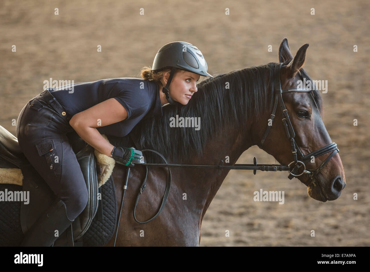 Side view of woman riding horse at ranch Stock Photo