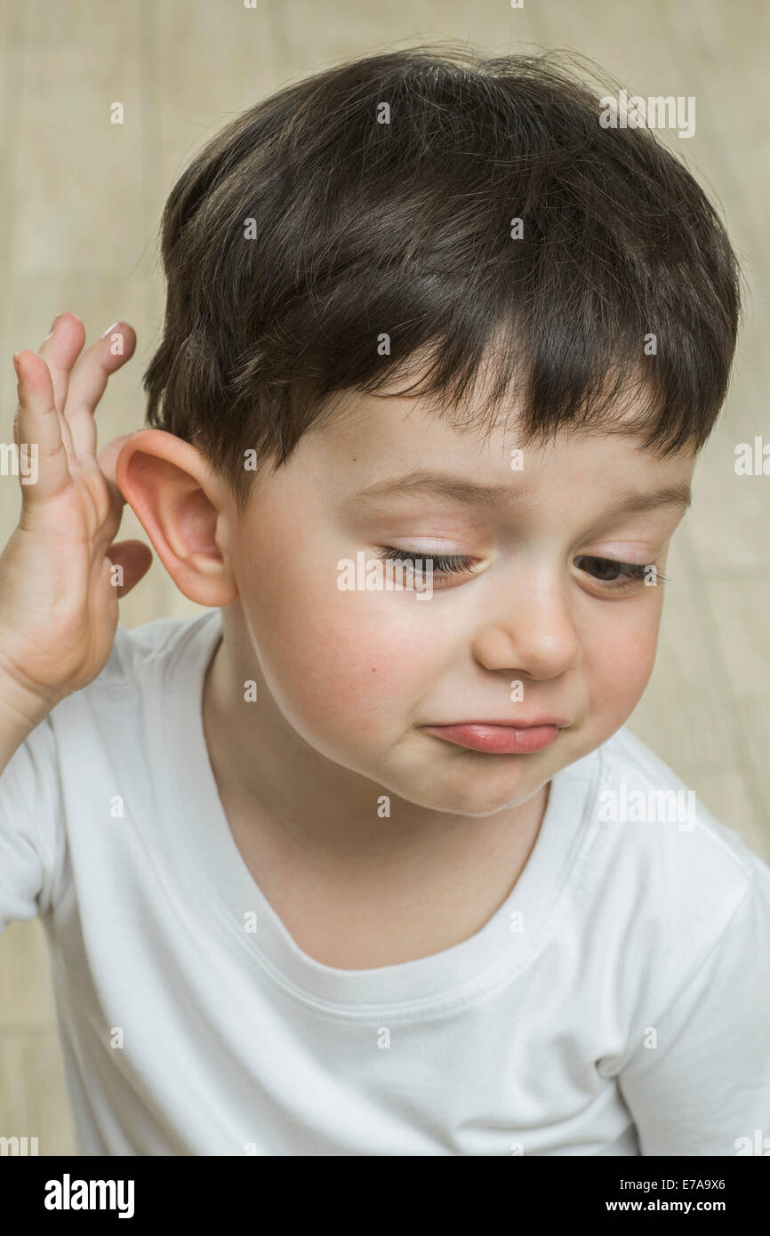 Cute boy scratching head at home Stock Photo
