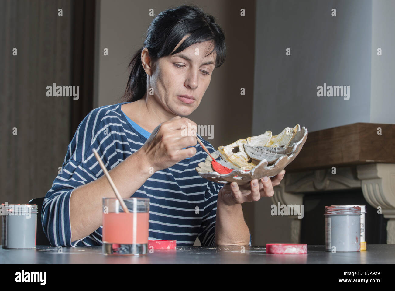 Creative woman painting bowl at home Stock Photo
