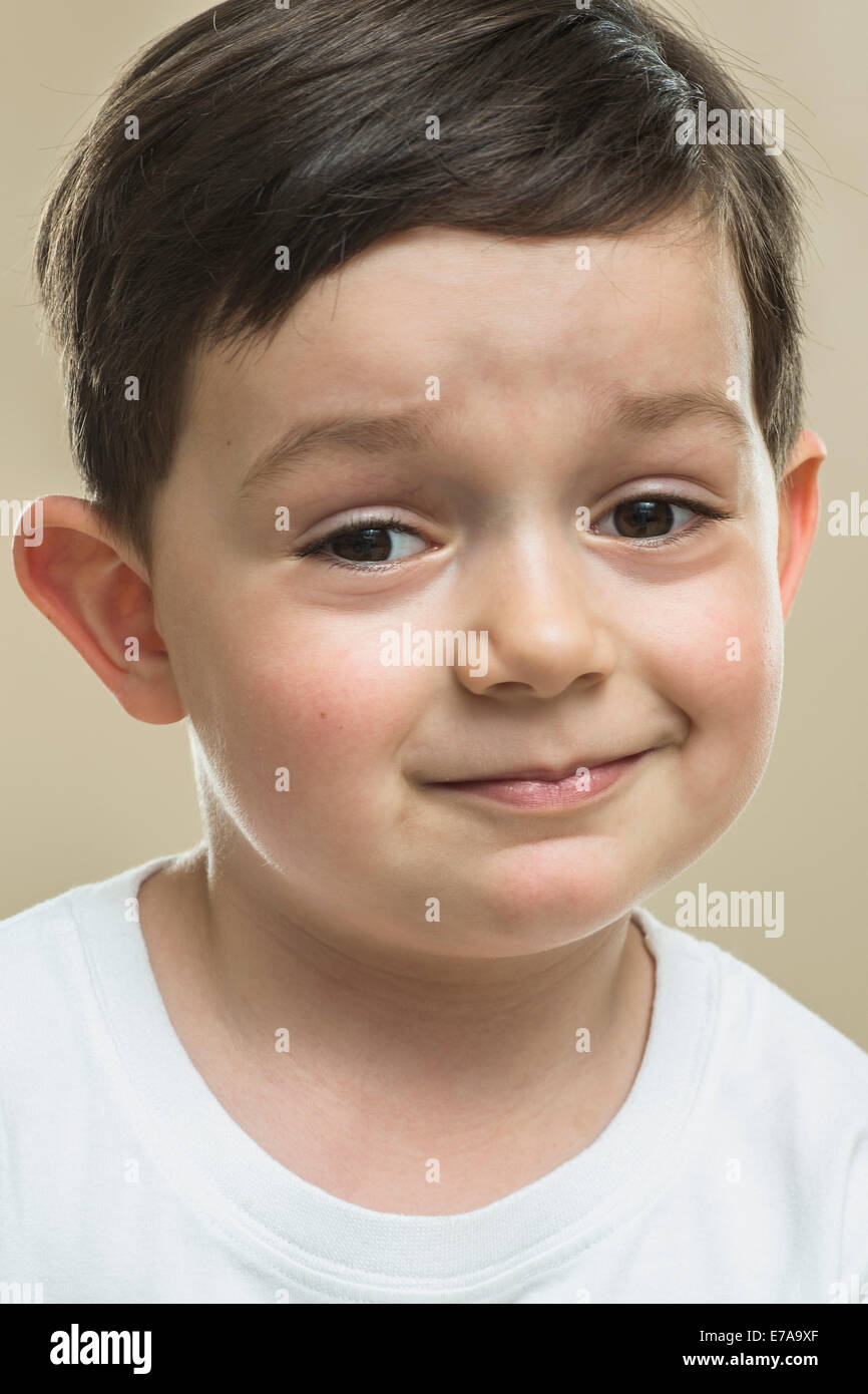 Portrait of boy smiling against beige background Stock Photo