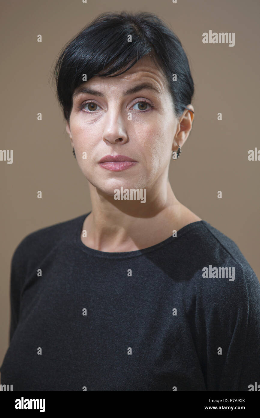 Portrait of serious woman against brown background Stock Photo